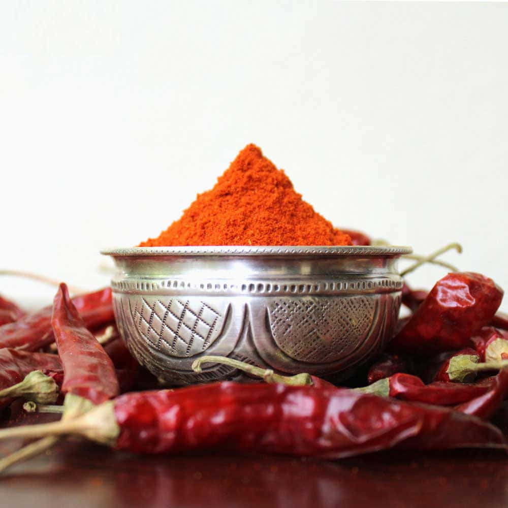 Vibrant Red Chili Powder In A Ceramic Bowl Wallpaper