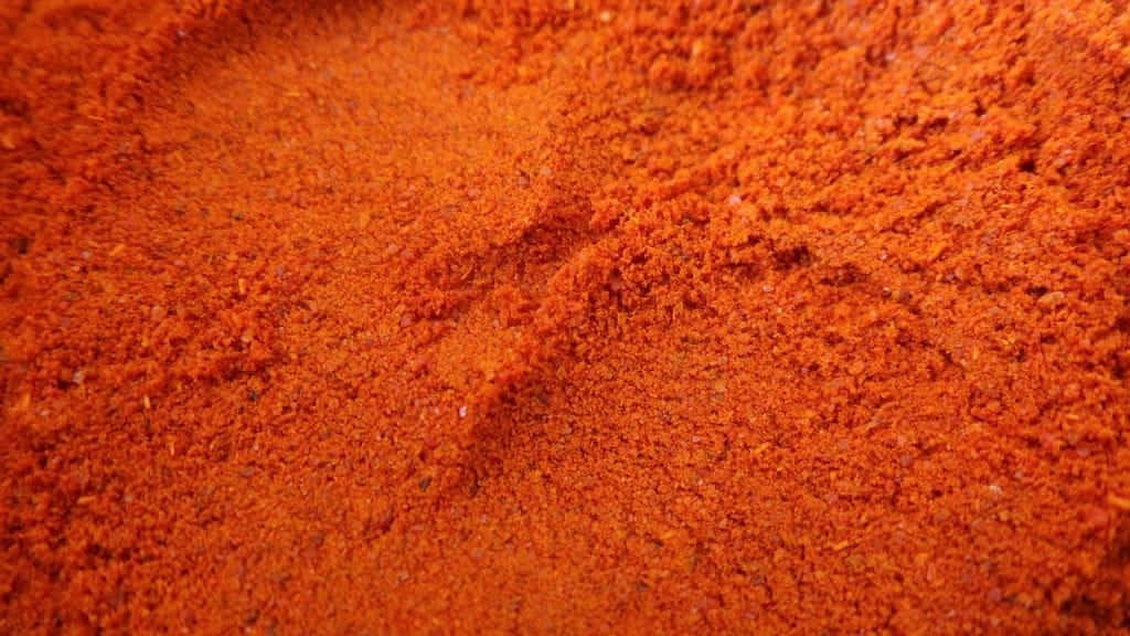 Vibrant Red Chili Powder In A Rustic Bowl Wallpaper