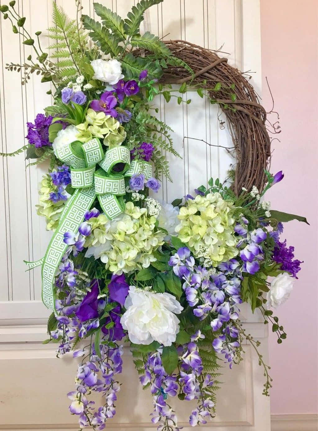 Vibrant Spring Wreath Adorning A Wooden Door Wallpaper