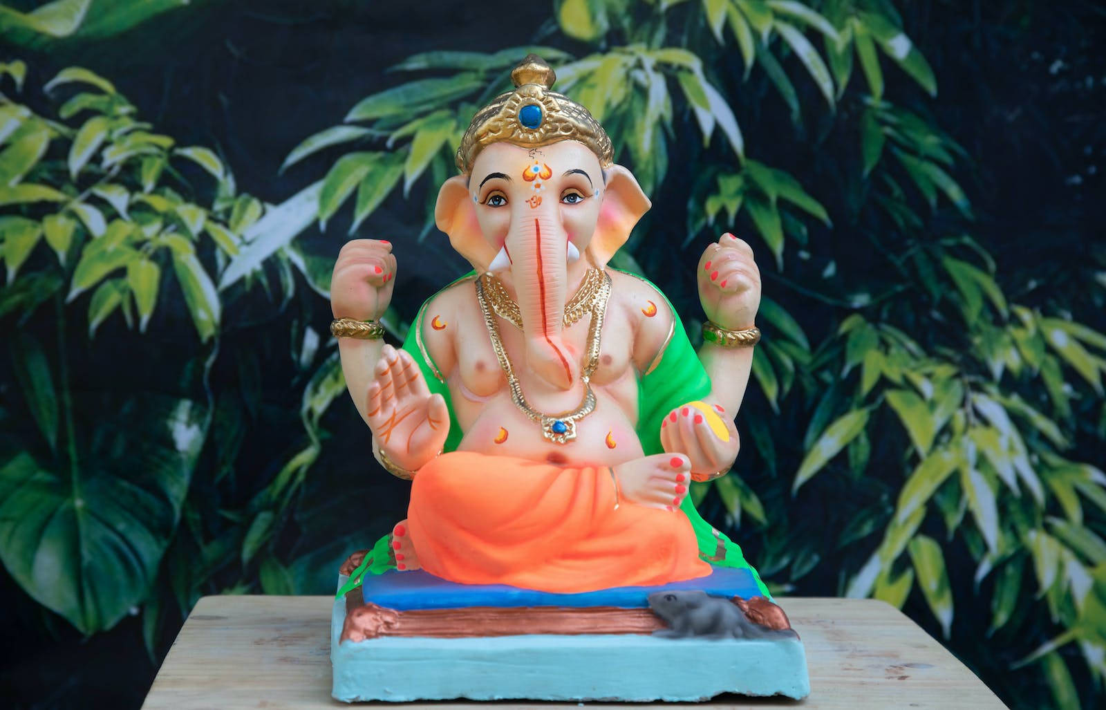 Vinayaka Figurine In Green And Orange Clothes Wallpaper