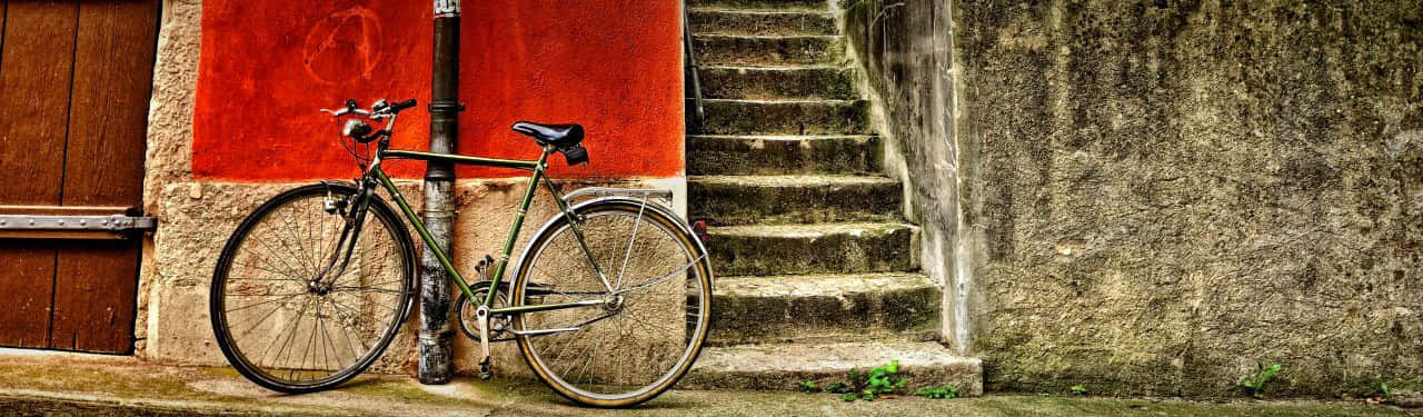 Vintage Bicycle Leaning Against Red Wall Wallpaper