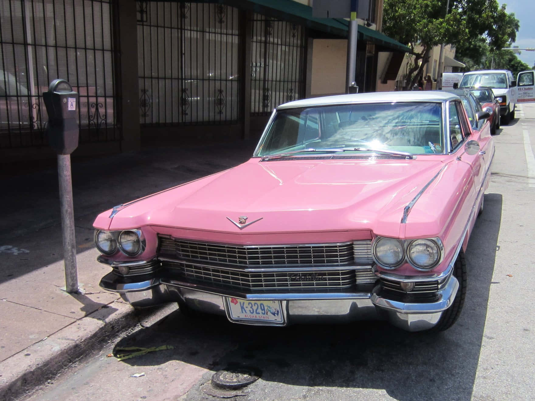 Vintage Pink Cadillac Under A Clear Sky Wallpaper