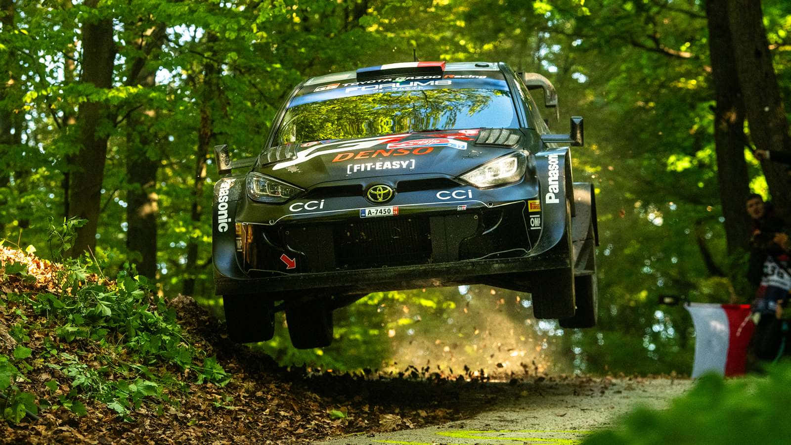 W R C Rally Car Jumpingin Forest Stage Wallpaper