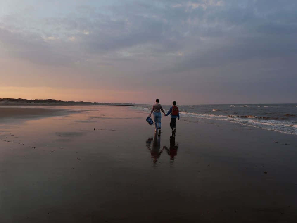 Walking Along The Beach At Sunset Wallpaper