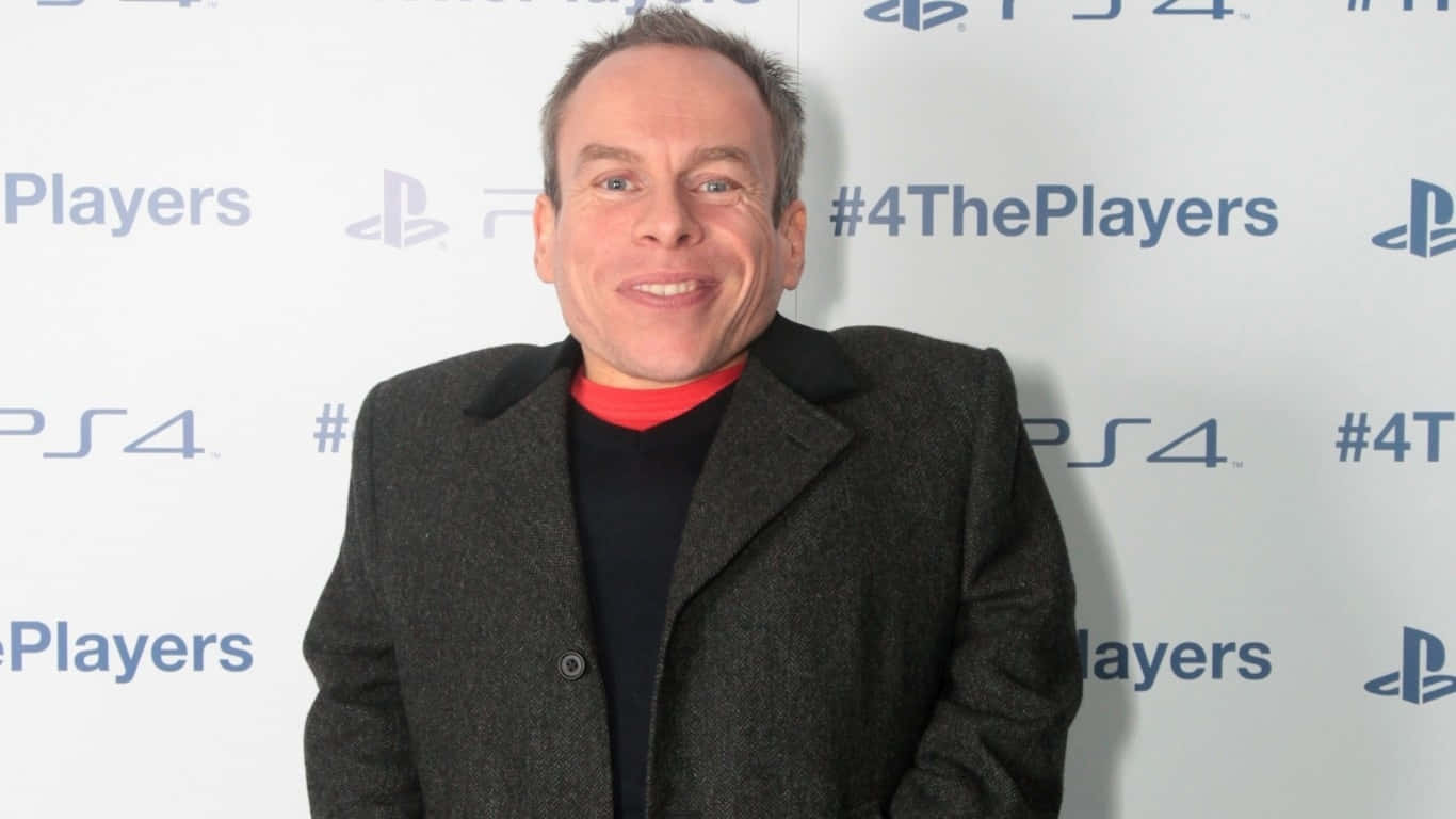 Warwick Davis Smiling At An Event Wallpaper