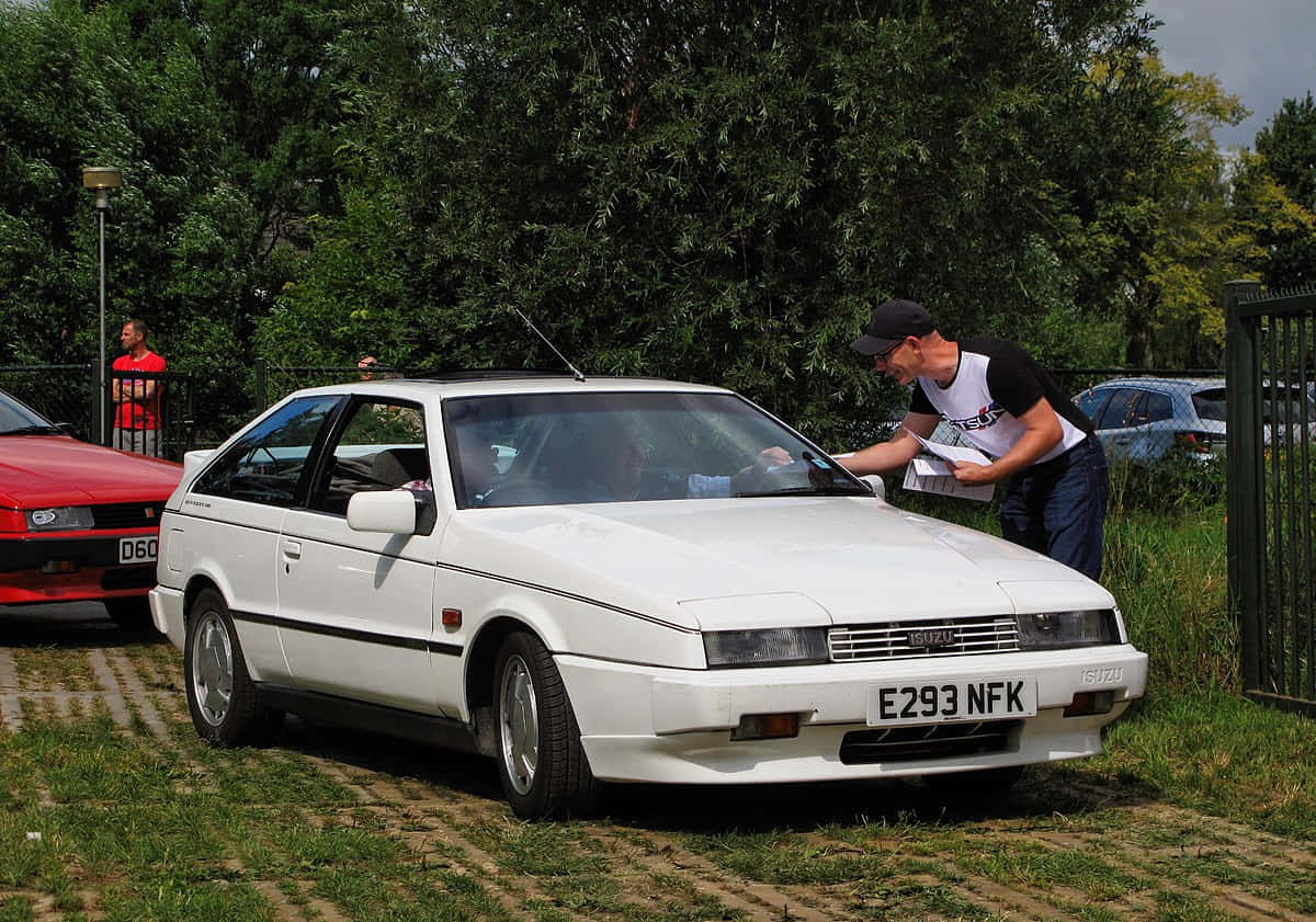 White Isuzu Impulse Parked Outdoors Wallpaper