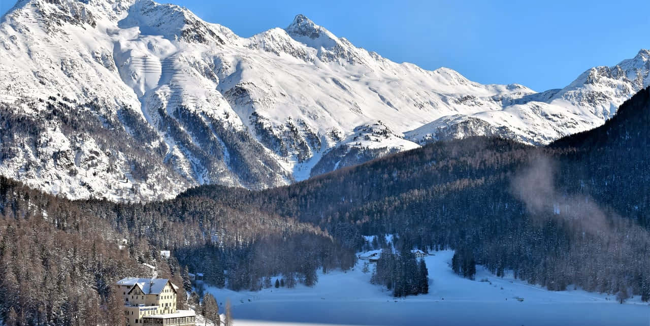 Winterthur_ Snowy_ Mountain_ Landscape_with_ Lake_and_ Building Wallpaper