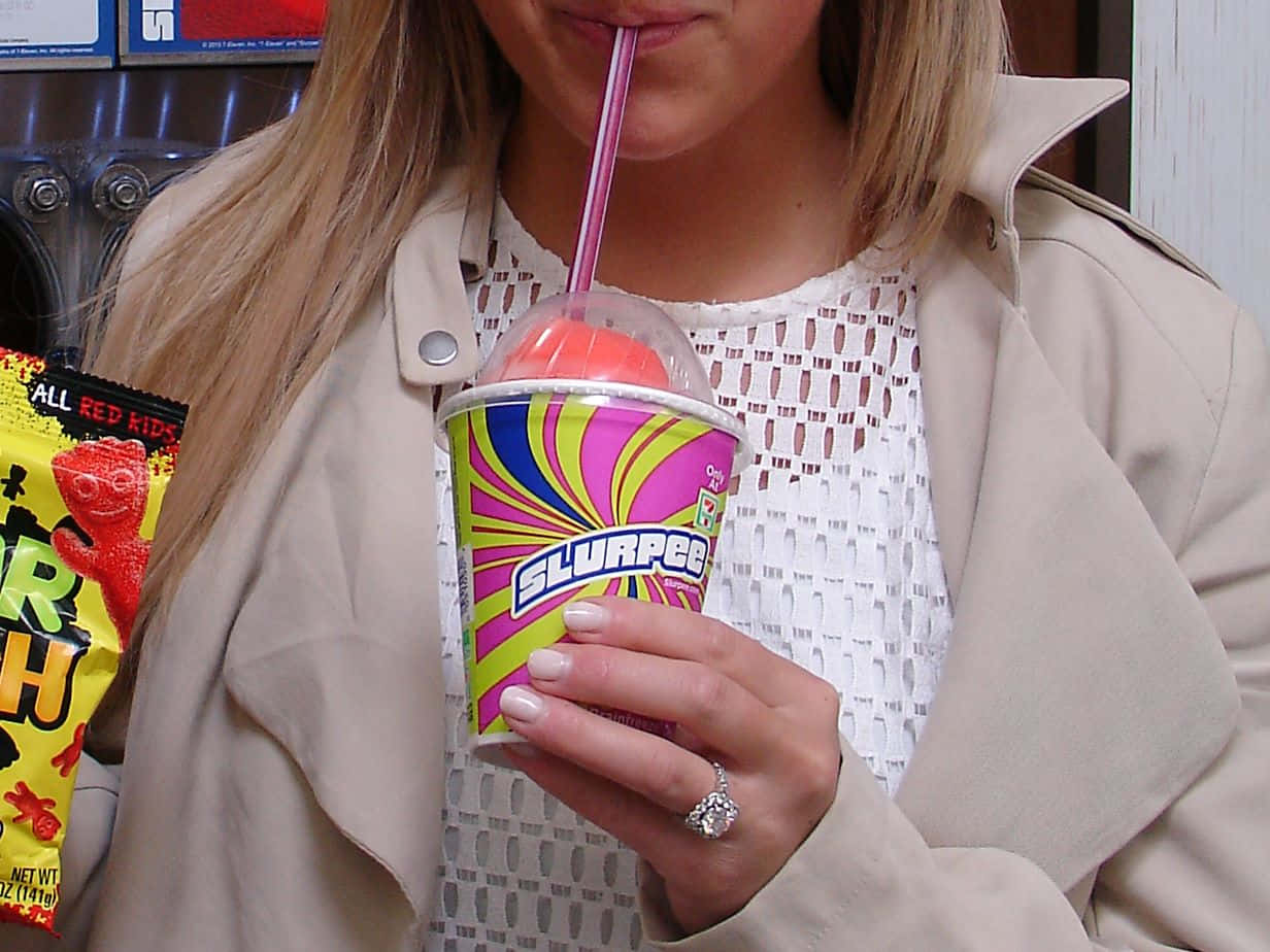 Woman Enjoying Slurpee Treat Wallpaper