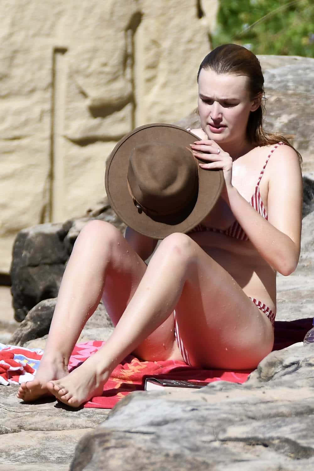 Woman_ Holding_ Hat_at_ Beach Wallpaper