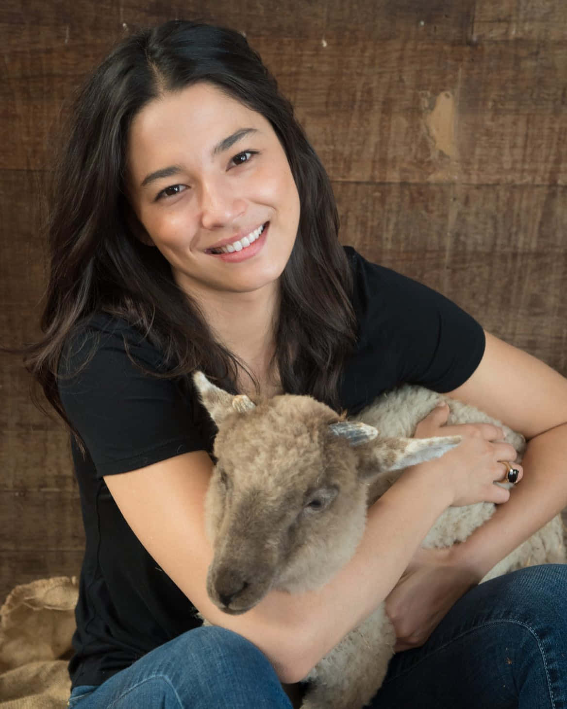 Woman Holding Lamb Wooden Backdrop Wallpaper