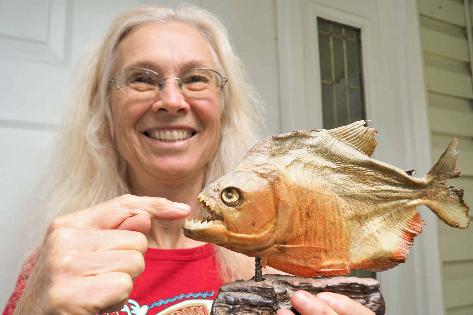 Woman Holding Piranha Statue Wallpaper