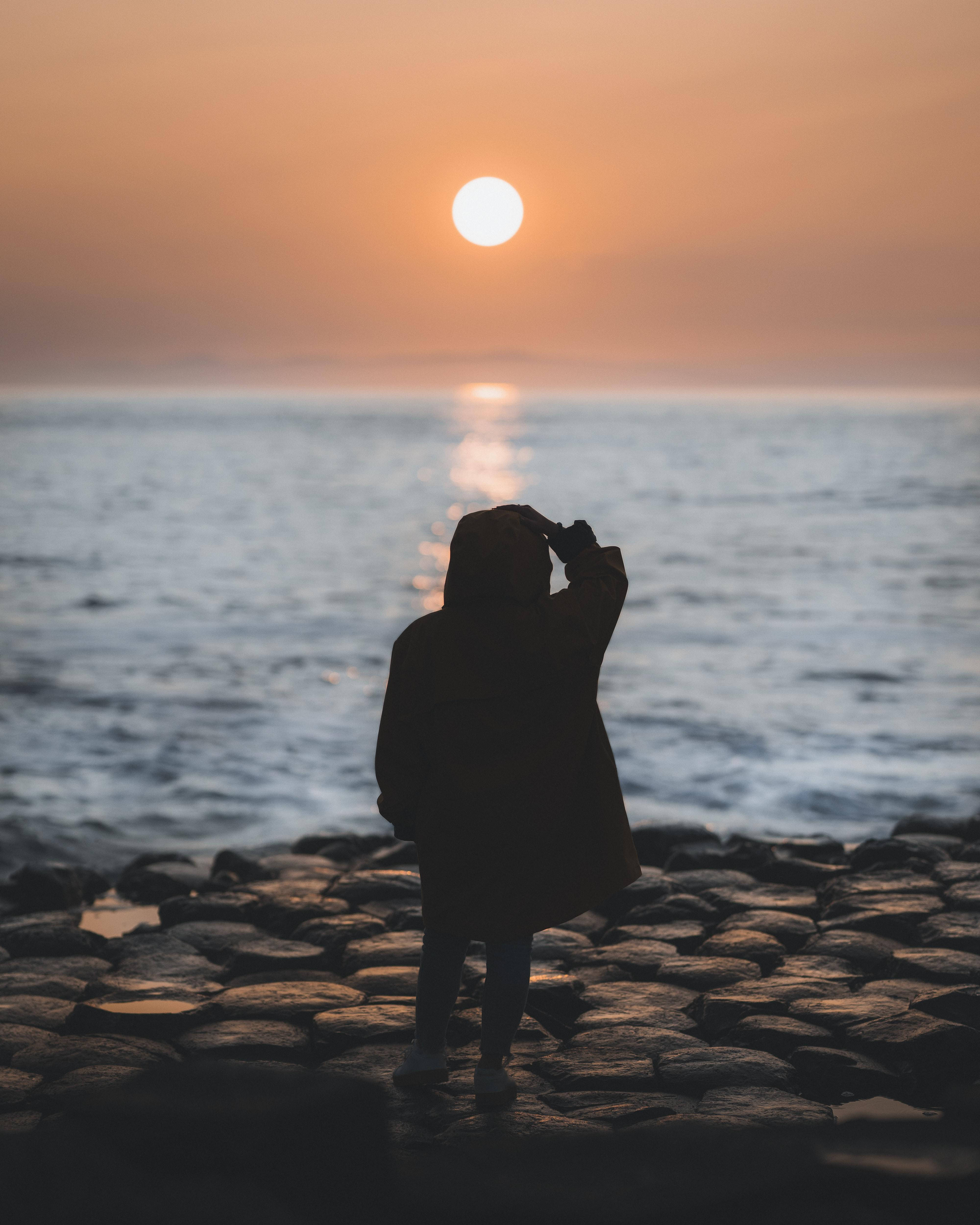 Woman On Rocky Beach Alone Phone Wallpaper