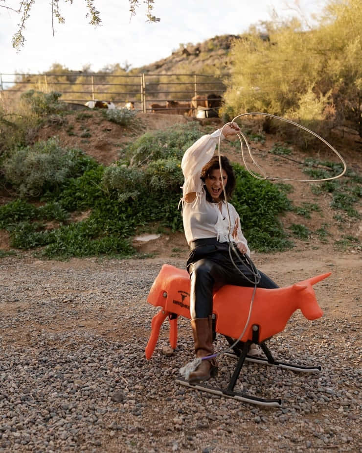 Woman Riding Rocking Horse With Lasso Wallpaper