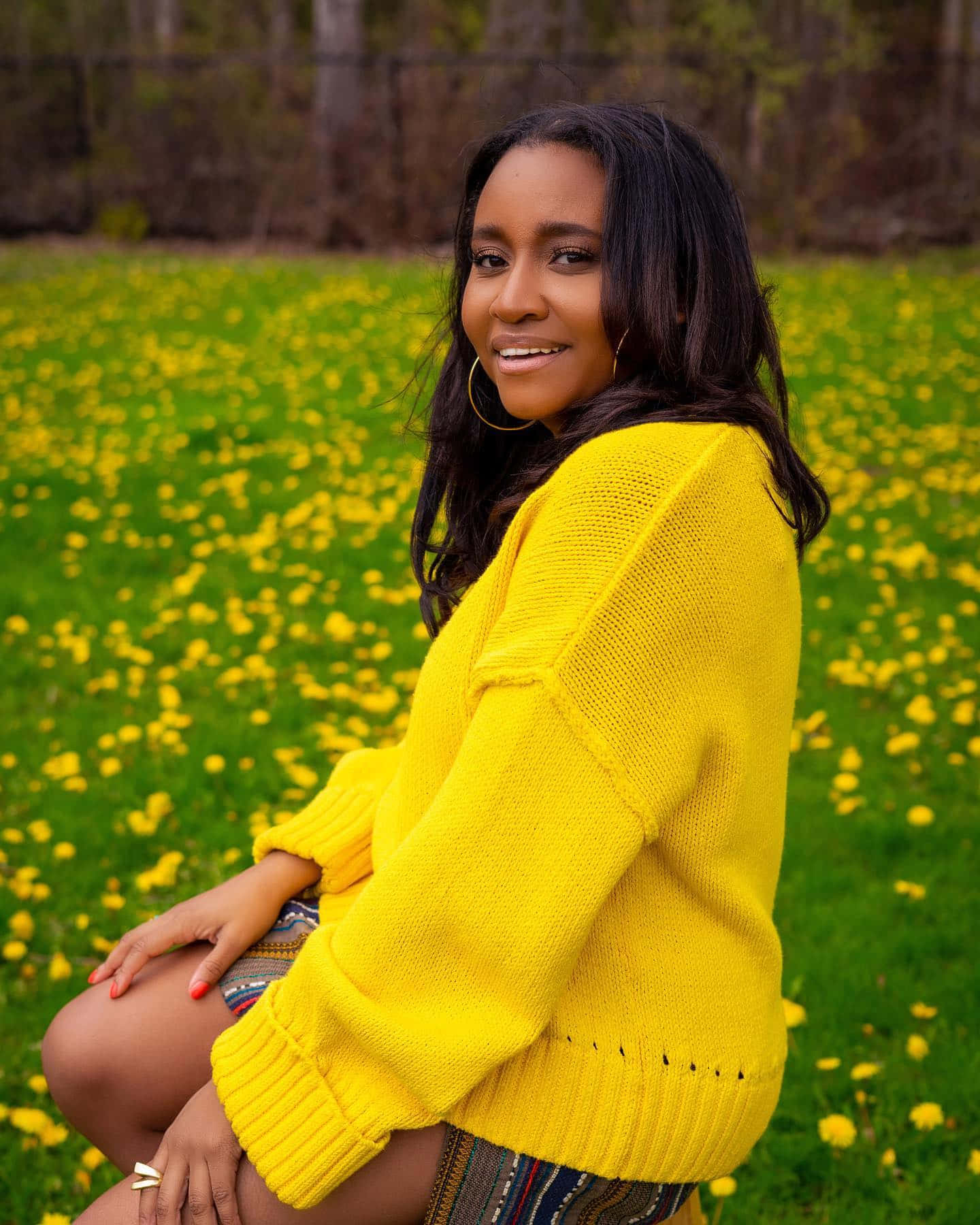 Womanin Yellow Sweater Sittingin Fieldof Dandelions Wallpaper