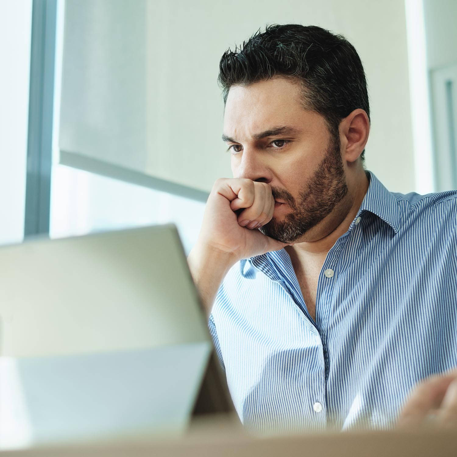 Worry-stricken Man Touches Forehead As He Reads Wallpaper