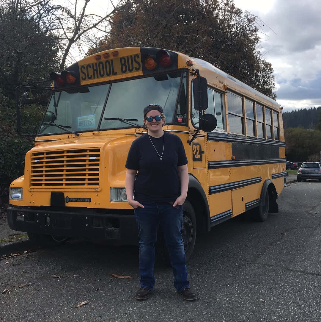 Yellow School Bus Parked On A Sunny Day Wallpaper