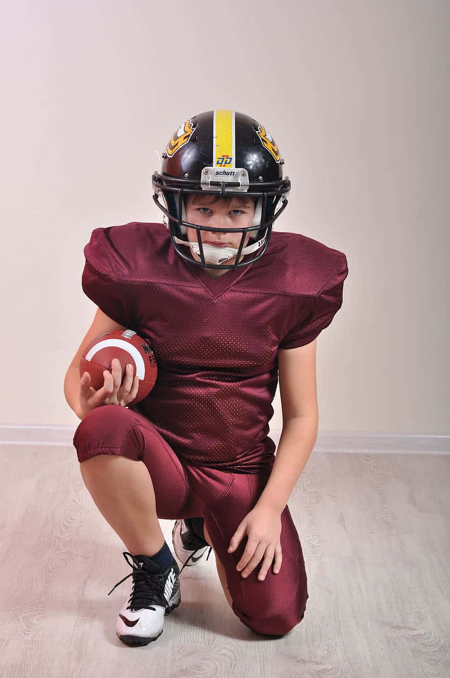 Youth Football Player Ready For Game Wallpaper