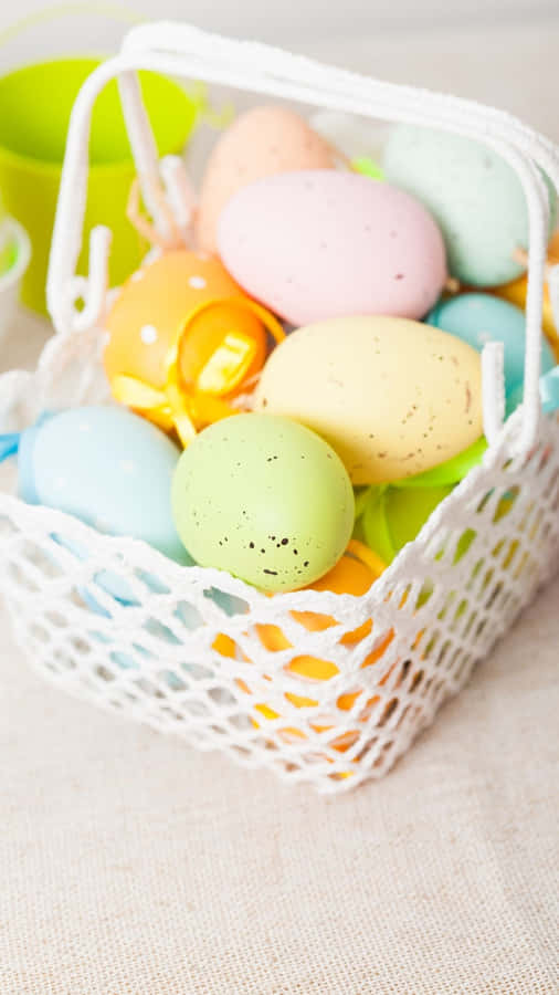 A Basket Of Colorful Easter Eggs On A Table Wallpaper