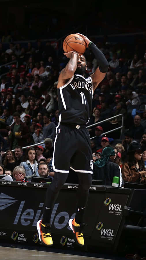 A Basketball Player Is In The Air While Dribbling Wallpaper