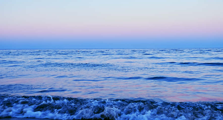 A Beach With Waves At Dusk Wallpaper