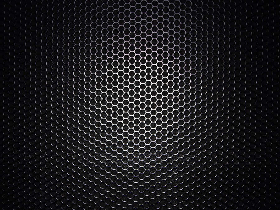 A Black Metal Grille With Holes In It Wallpaper
