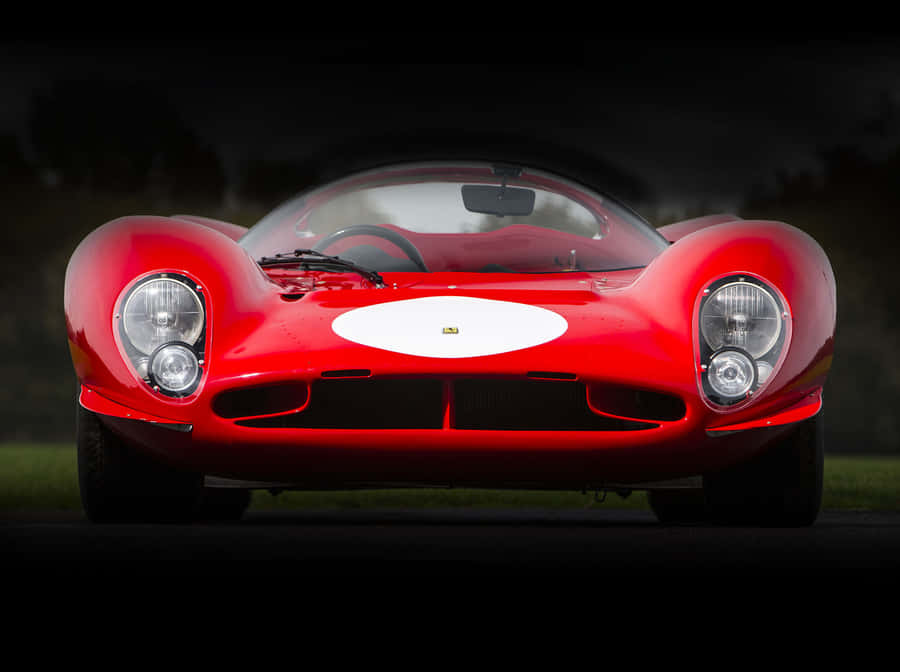 A Classic Yellow Ferrari Glistening In The Summer Sun Wallpaper