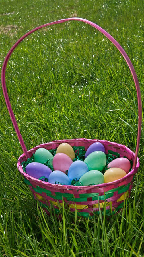 A Colorful Easter Basket Filled With Candy And Eggs Wallpaper