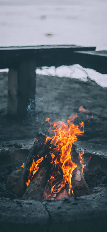 A Cozy Fall Bonfire Surrounded By Colorful Autumn Leaves Wallpaper