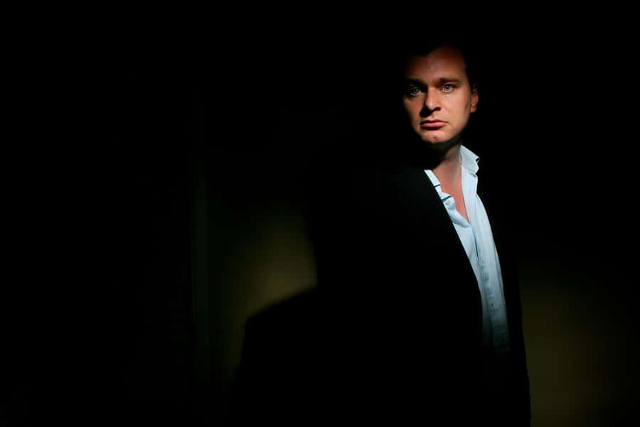 A Creative Portrait Of Genius Filmmaker Christopher Nolan Against A Stunning Backdrop Wallpaper