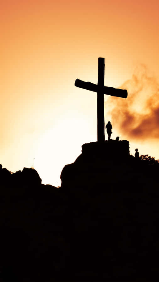 A Cross Is Silhouetted Against The Sunset Wallpaper