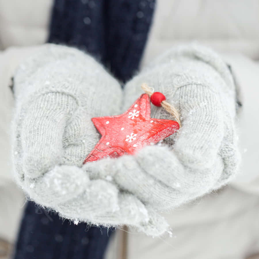 A Cute And Cozy Pair Of Mittens On A Wooden Surface Wallpaper