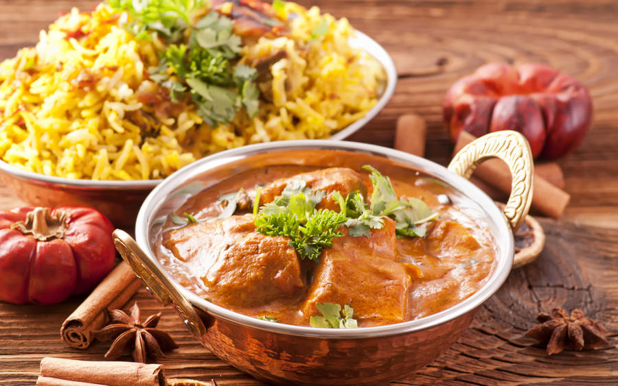 A Delectable Lunch With Butter Chicken And Biryani Rice Wallpaper