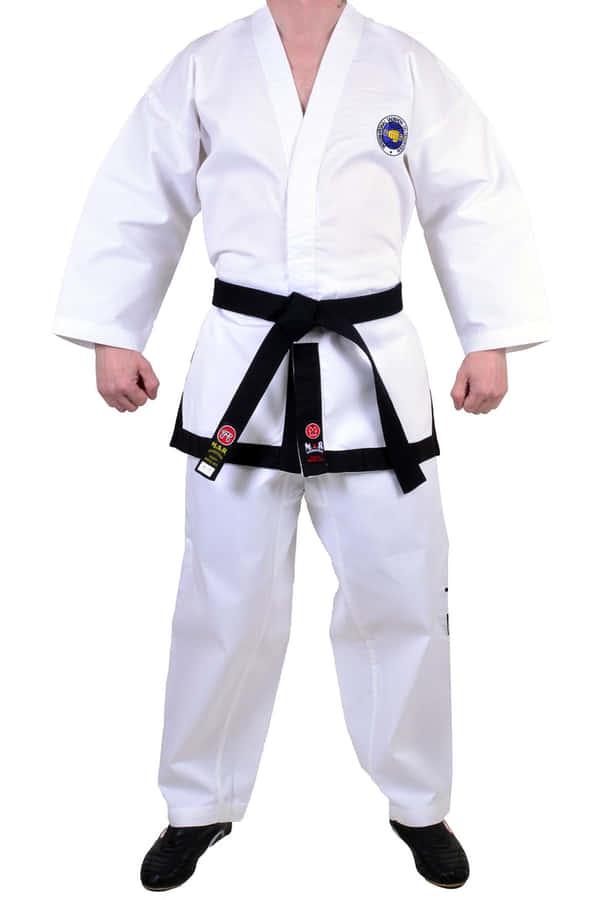 A Focused Student In Taekwondo Uniform Prepares To Throw A Kick Wallpaper