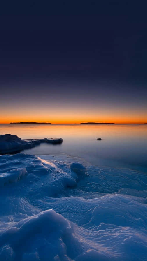 A Frozen Lake With Ice And Snow On It Wallpaper