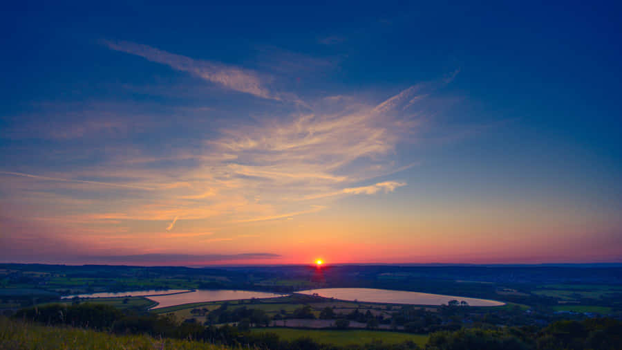 A Golden Sky Filled With Cirrus Clouds During A Sunset Wallpaper
