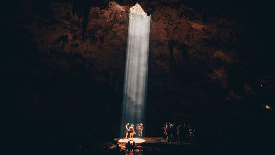 A Group Of Tourists Exploring An Impressive Natural Cave Wallpaper