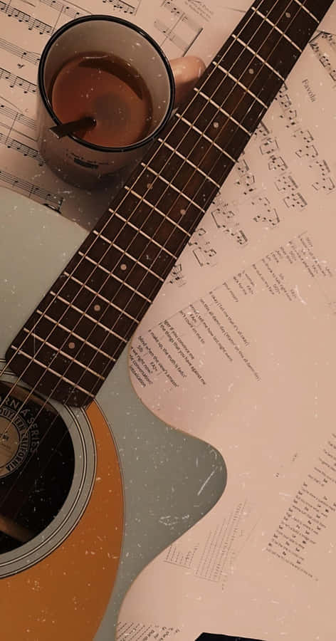 A Guitar And Cup Of Coffee On A Sheet Of Music Wallpaper