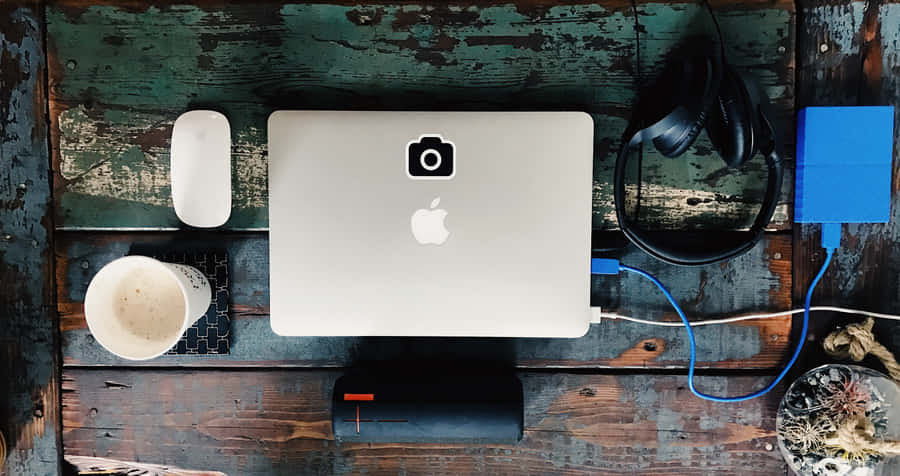 A Laptop, Phone, And Other Items On A Wooden Table Wallpaper