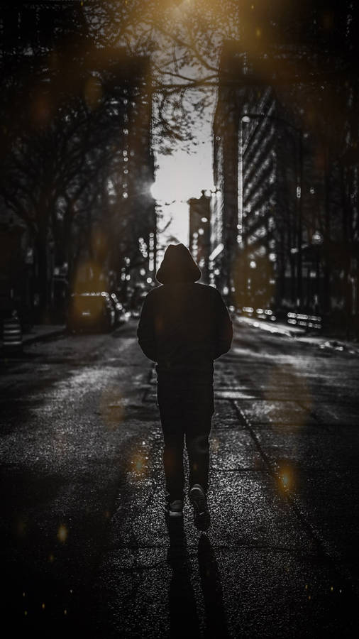A Lonely Boy Cautiously Walking Into The Darkness Wallpaper