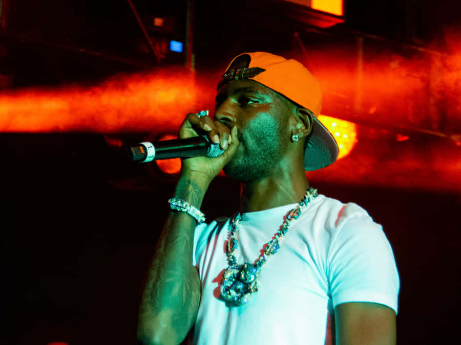 A Man In An Orange Hat Is Holding A Microphone Wallpaper