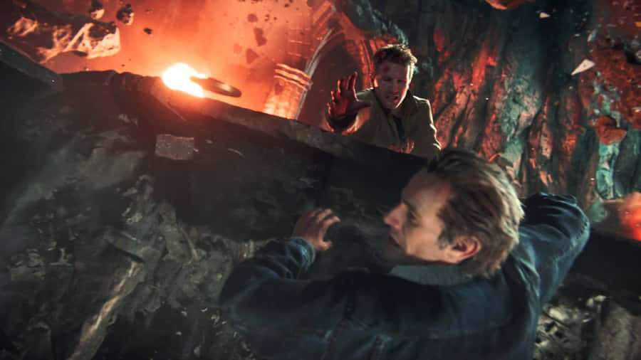 A Man Is Standing In A Cave With A Fire Wallpaper