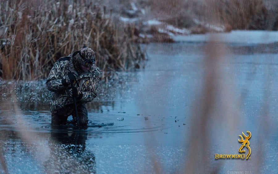 A Man Is Standing In A Pond With Reeds Wallpaper