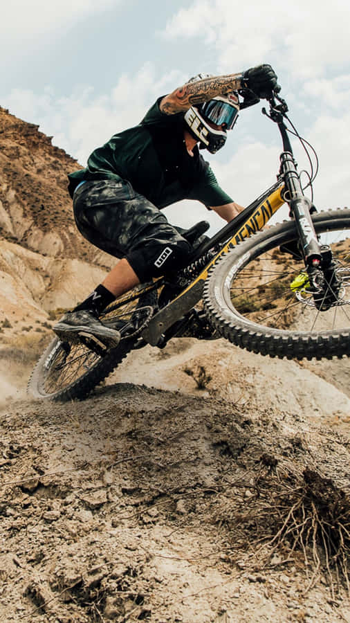 A Man Riding A Mountain Bike In The Desert Wallpaper