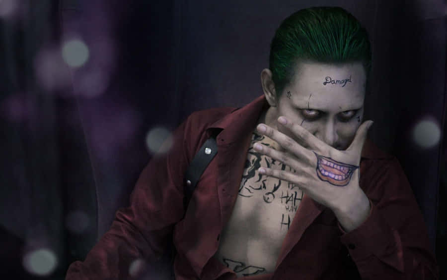 A Man With Green Hair And Tattoos Is Sitting On A Chair Wallpaper