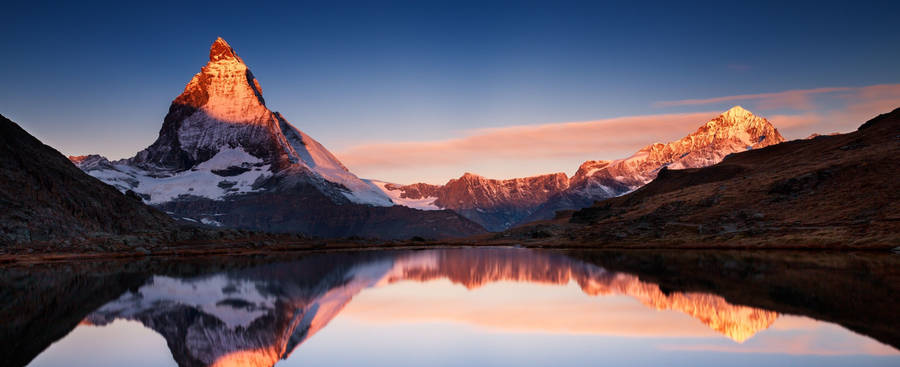 A Mountain Range Is Reflected In A Lake Wallpaper