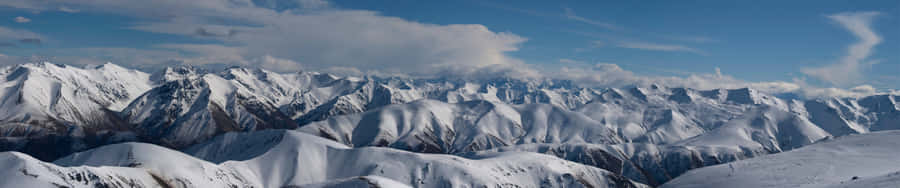 A Mountain Range With Snow Covered Mountains And Clouds Wallpaper