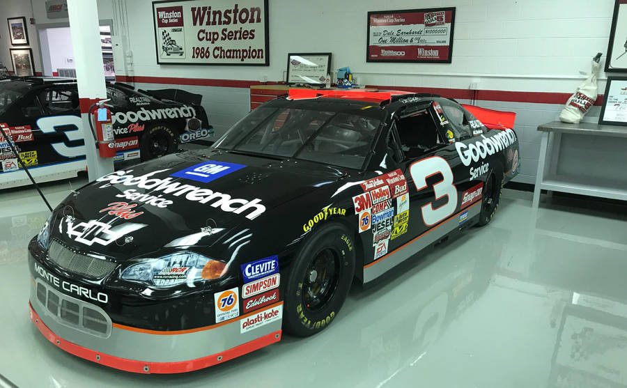A Nascar Car Is Parked In A Garage Wallpaper