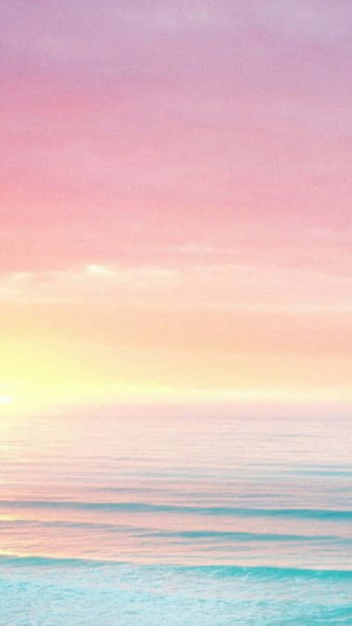 A Pink And Purple Sunset Over The Ocean Wallpaper