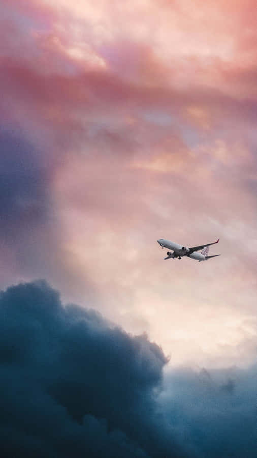 A Plane Flying Through A Cloudy Sky Wallpaper