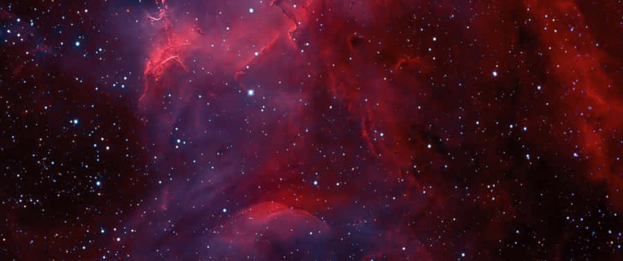 A Red And Blue Nebula With Stars In The Background Wallpaper